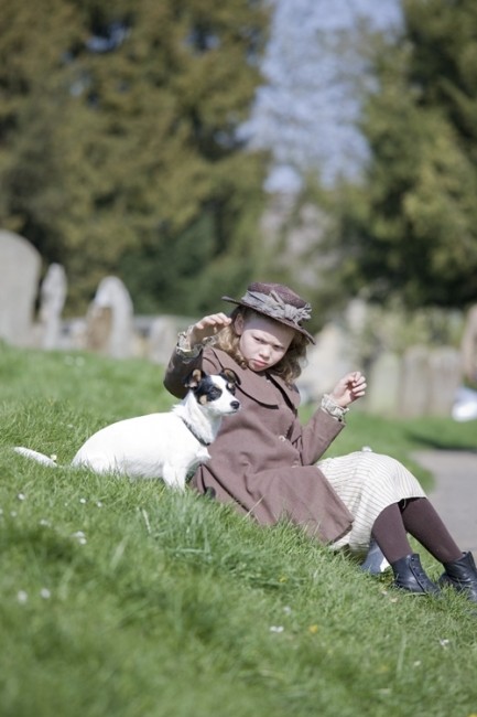 Une petite fille avec son chien dans l'herbe
