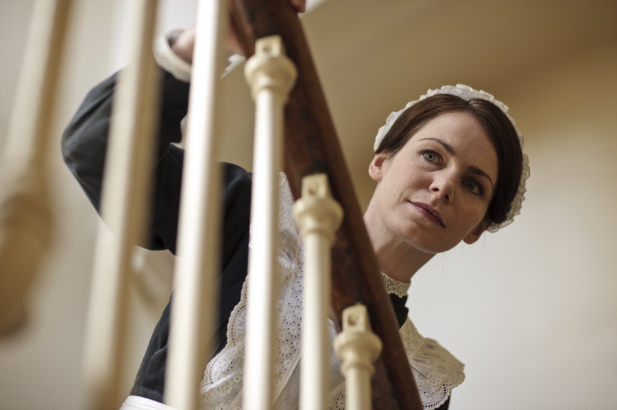 Jane Moorsum regarde par dessus la rembarde d'escalier